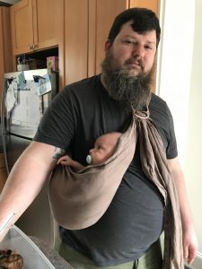 Merritt uses a covential tote sling to carry his son